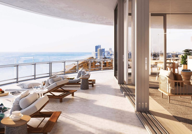 Eighty Seven Park, Miami Beach luxury and ultra luxury condos wraparound terrace lounge with chaise seating, open-air living space, and panoramic ocean and coastline views.