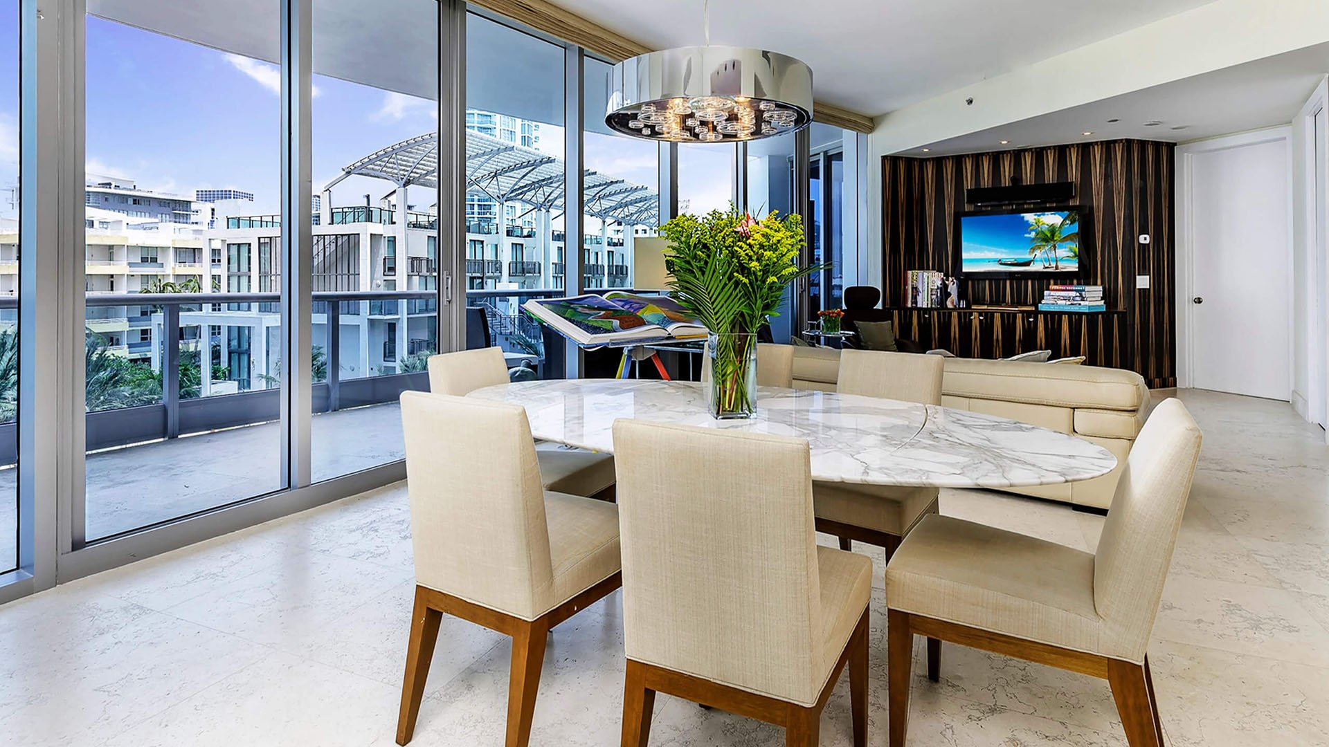 Marble dining room at Faena House in Miami Beach, luxury and ultra luxury condos with floor-to-ceiling windows, terrace access, soft neutral seating, and an open living area.