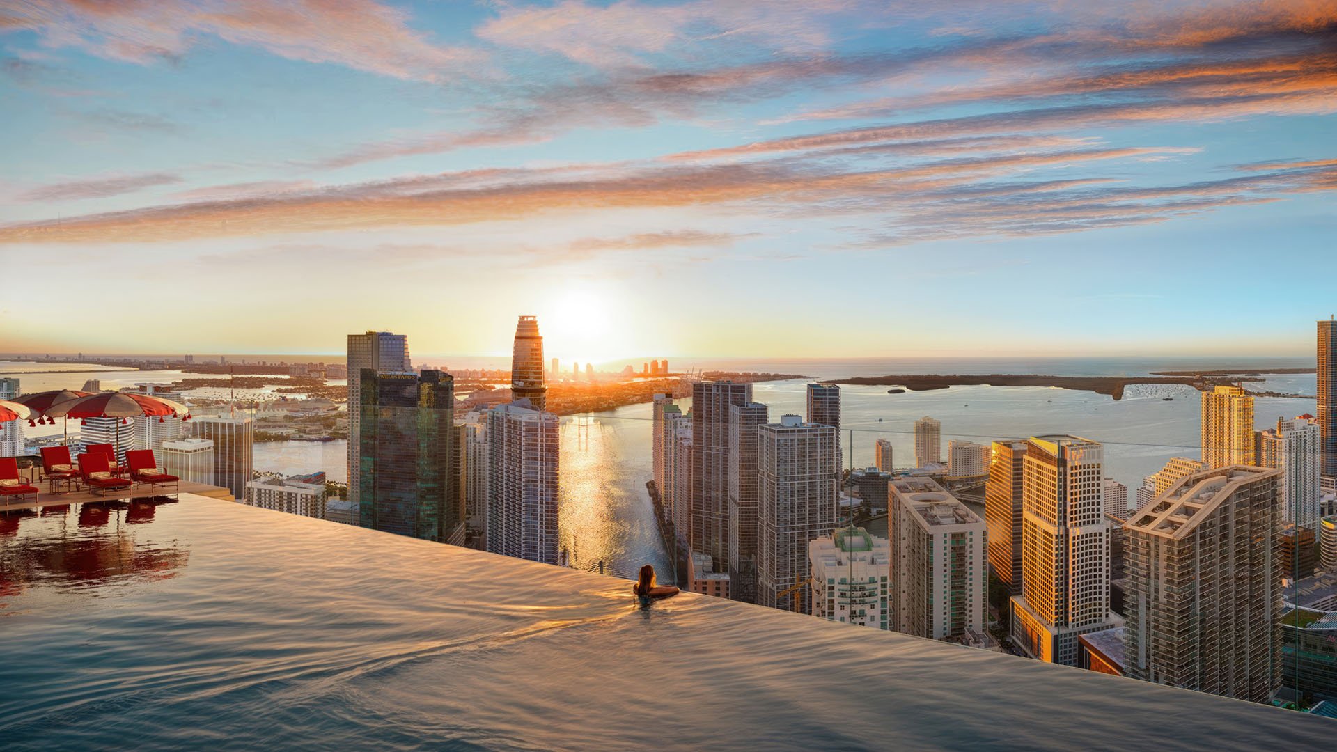 Faena Residences Miami rooftop infinity pool at sunrise with panoramic skyline and bay views, Downtown Miami. Luxury and ultra luxury preconstruction condos offering resort-level rooftop amenities and cabanas.