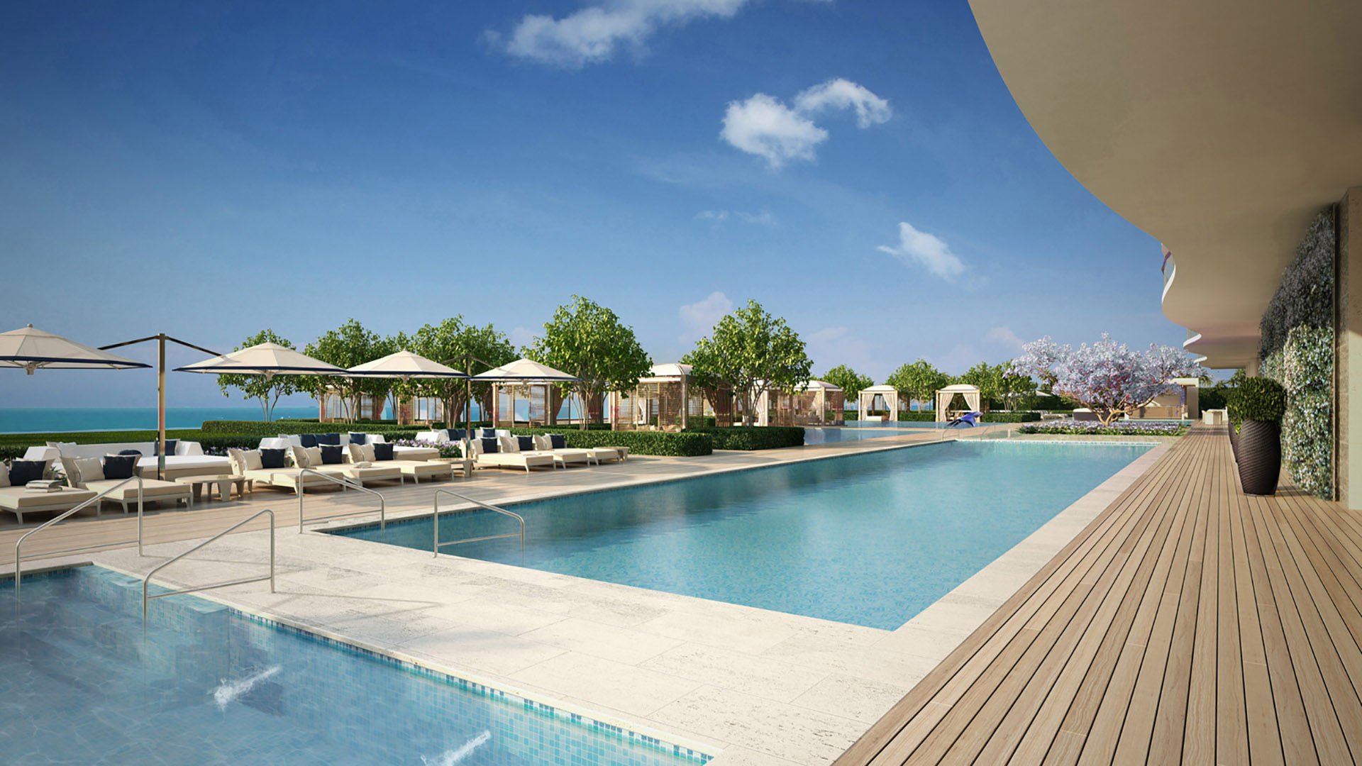 Long pool terrace at Fendi Chateau Residences in Surfside with sun loungers, cabanas, and ocean-adjacent landscaping for luxury and ultra luxury condos.