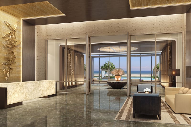 Reception lobby at Fendi Chateau Residences in Surfside with a marble desk, seating area, and framed ocean view, introducing luxury and ultra luxury condos.