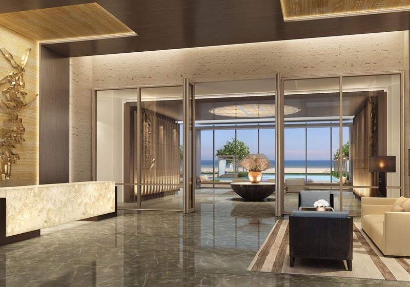 Reception lobby at Fendi Chateau Residences in Surfside with a marble desk, seating area, and framed ocean view, introducing luxury and ultra luxury condos.