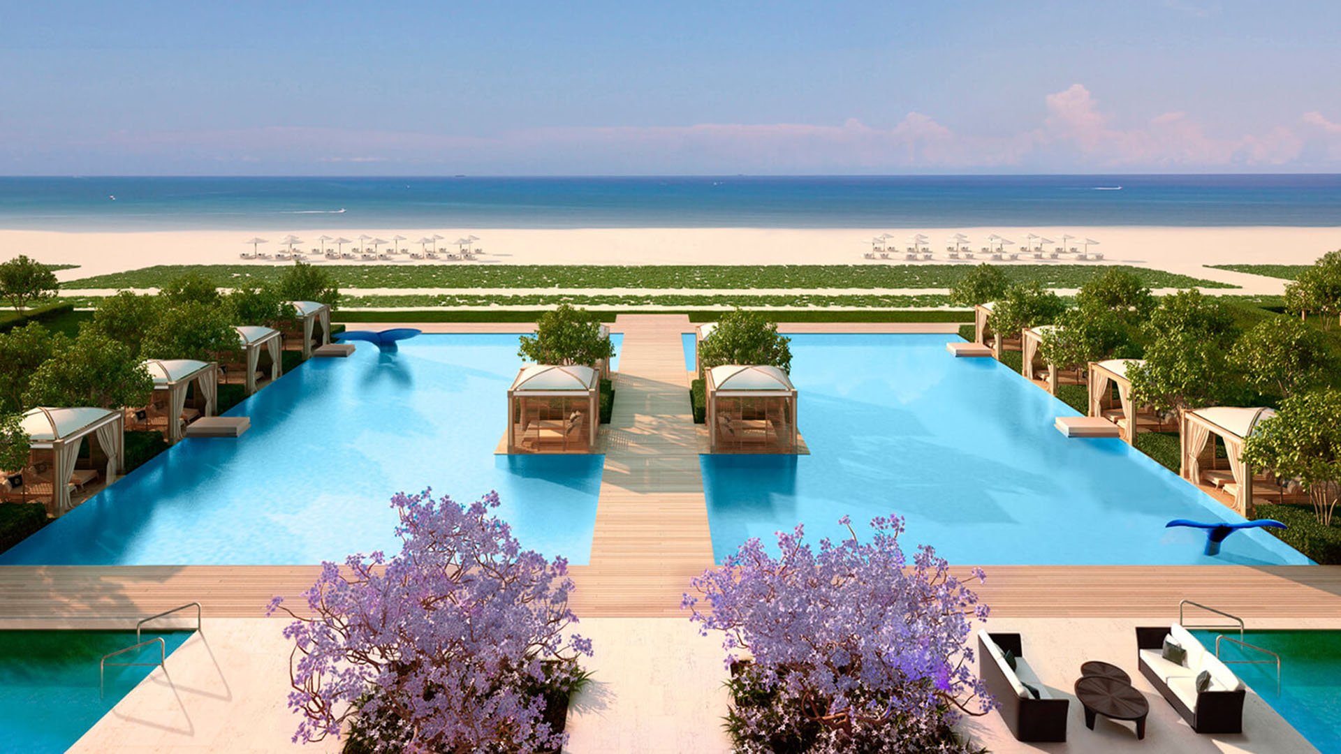 Symmetrical oceanfront infinity pool at Fendi Chateau Residences in Surfside with cabanas, wooden walkways, and beach views, elevating luxury and ultra luxury condos.