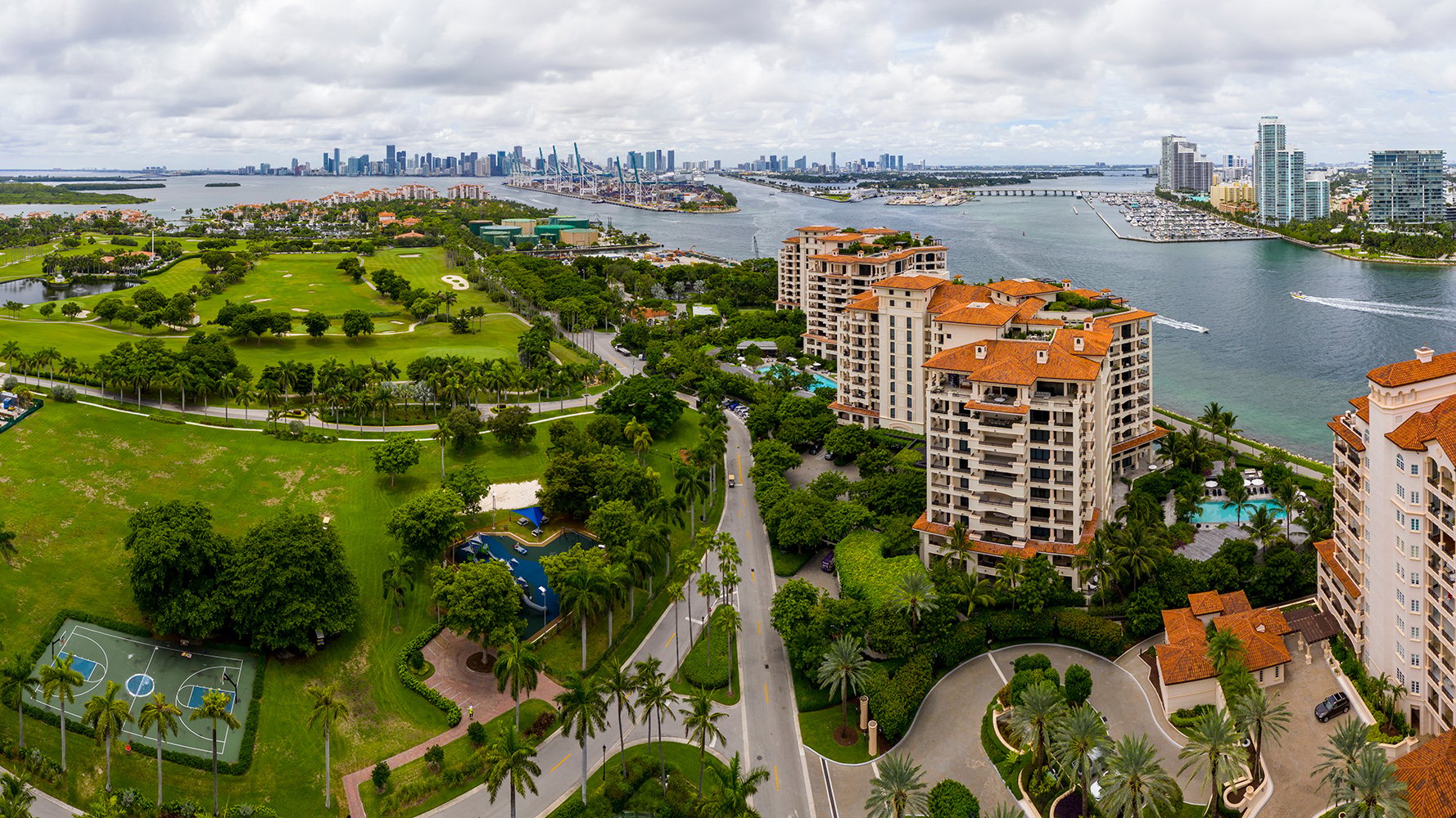 Fisher Island, Miami panorama with residential towers and golf course—private‑club lifestyle for luxury and ultra luxury condos; resale favored.