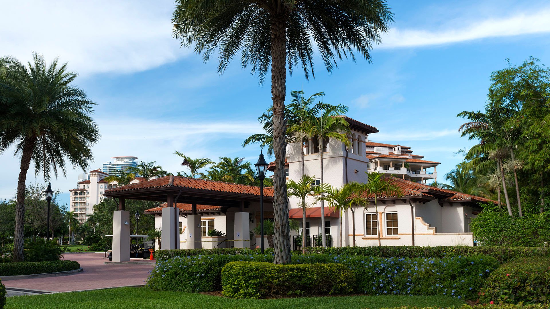 Fisher Island luxury and ultra luxury condos family amenity with a school entrance, palm courtyard, and Mediterranean style buildings.