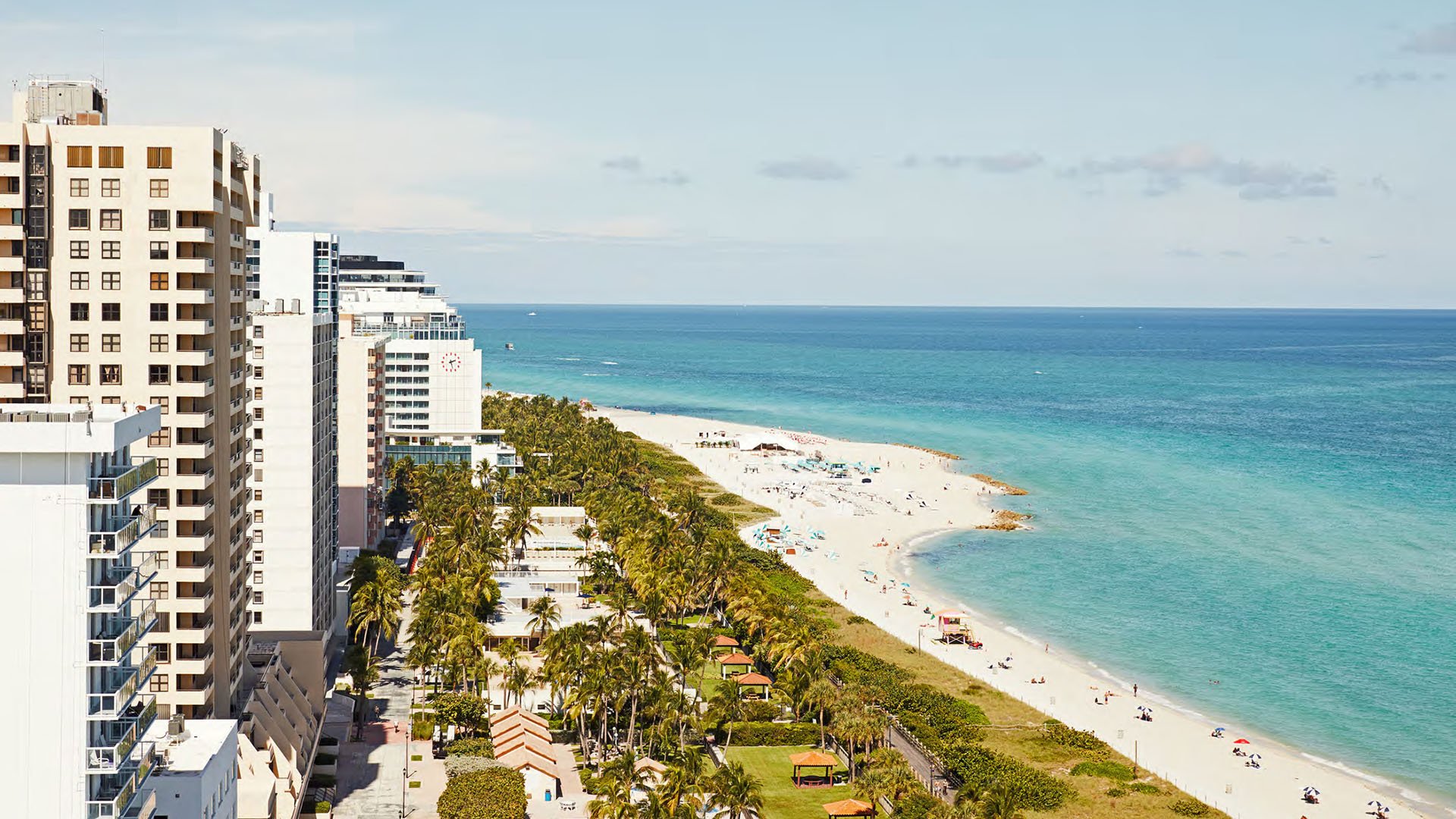 Aerial beach coastline near Five Park in Miami Beach, luxury and ultra luxury condos with turquoise water, white sand and a line of oceanfront buildings.