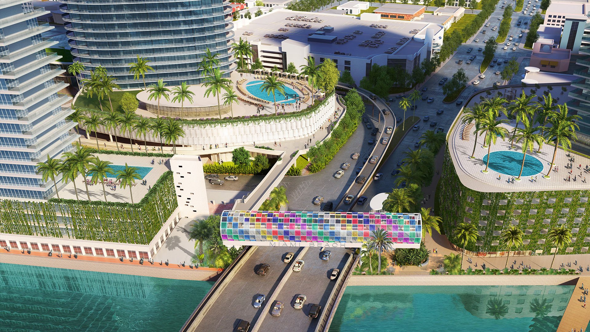 Aerial view of the pedestrian bridge, pool decks and tower at Five Park in Miami Beach, luxury and ultra luxury condos above the waterfront road.