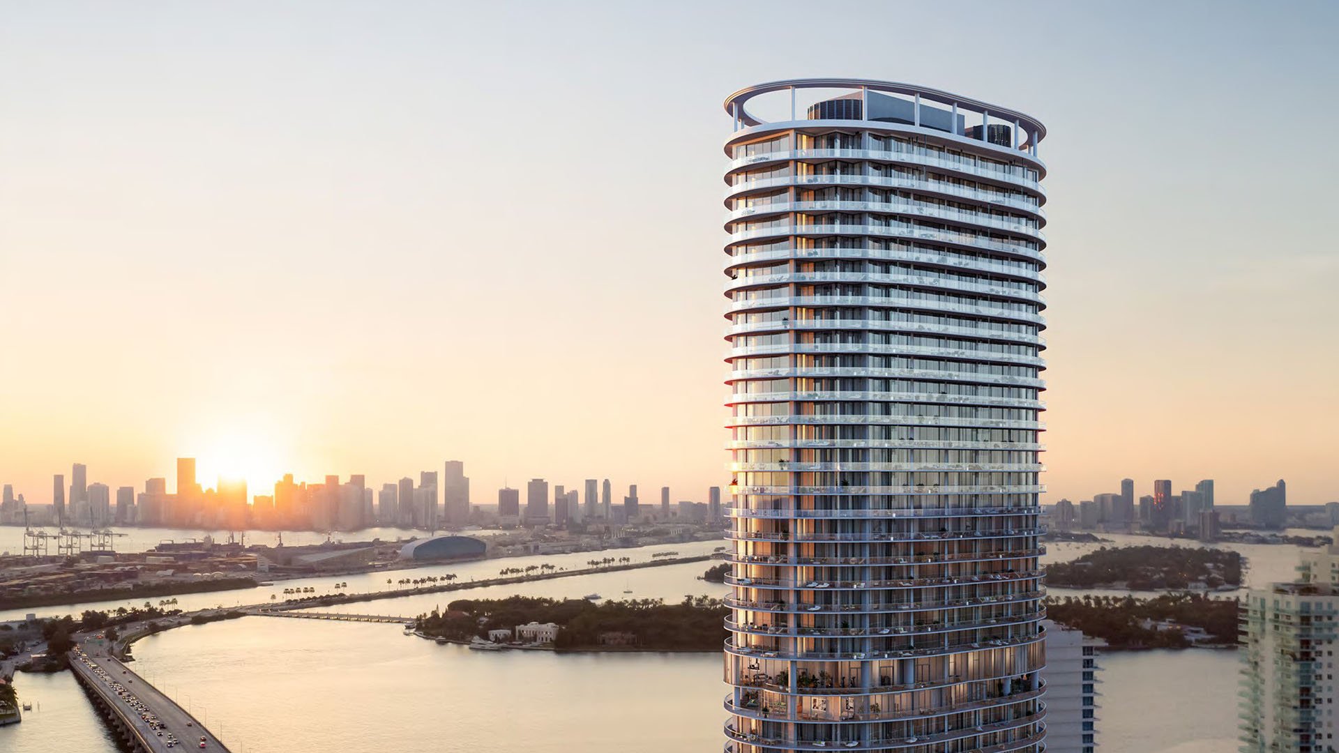 Sunset exterior of the curved tower at Five Park in Miami Beach, luxury and ultra luxury condos with glowing glass balconies and skyline views.