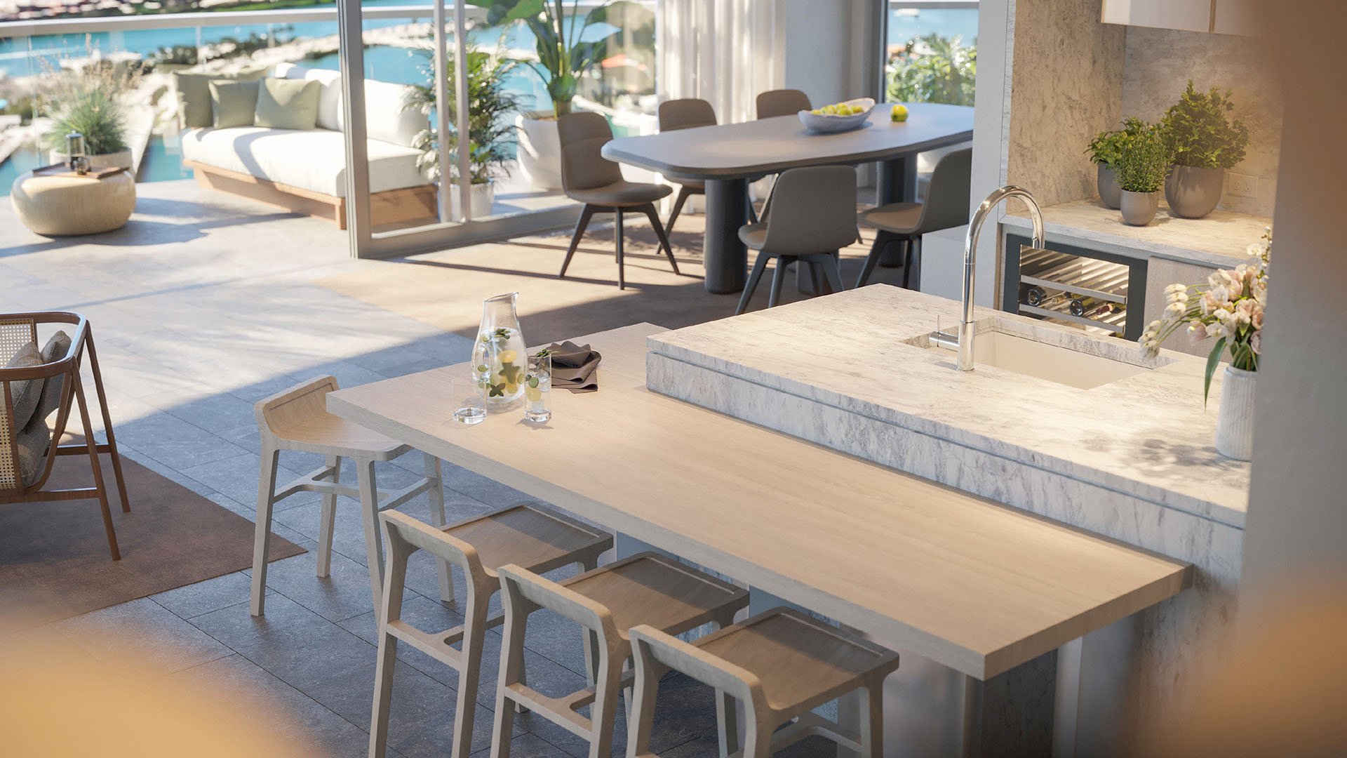 Marble island kitchen looking toward the terrace at Five Park in Miami Beach, luxury and ultra luxury condos with indoor outdoor dining and lounge seating.