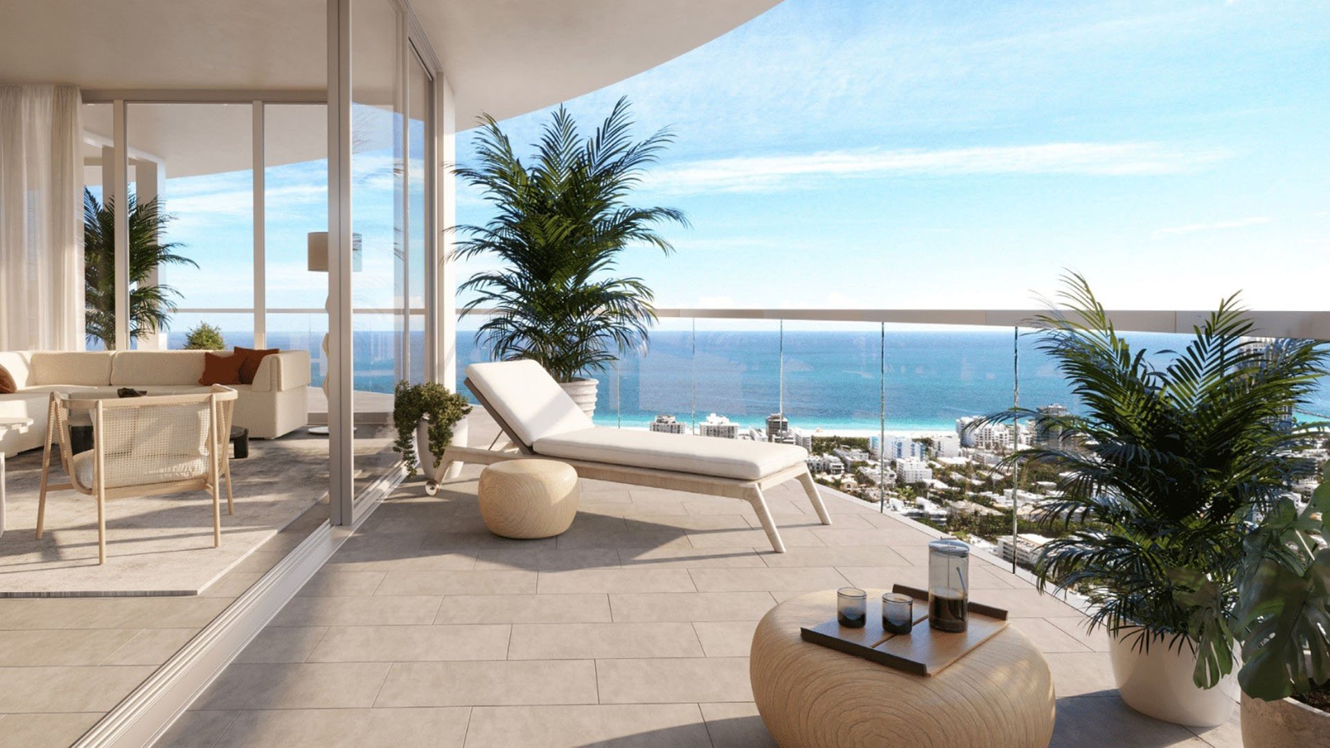 Private curved balcony with chaise lounge, outdoor seating and open ocean horizon at Five Park in Miami Beach, luxury and ultra luxury condos with a serene waterfront terrace.
