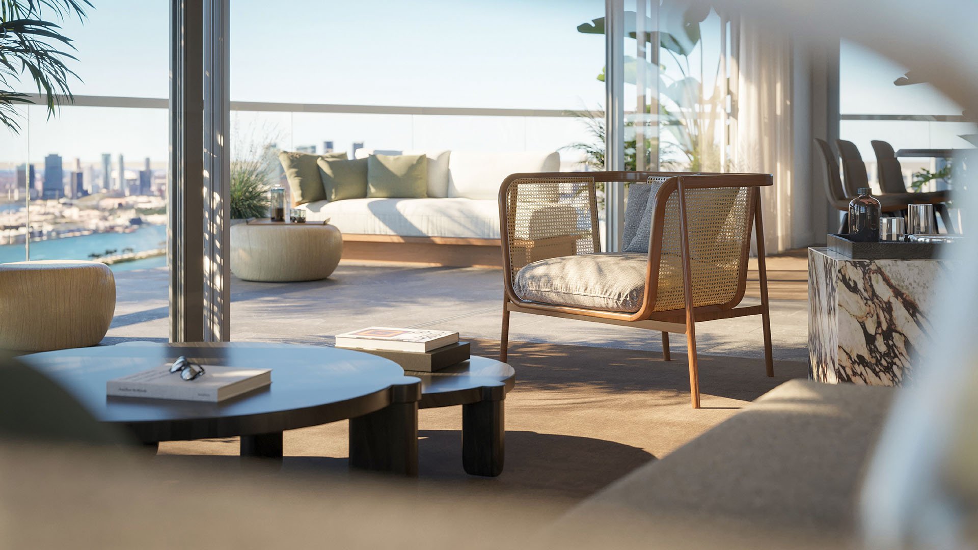 Close view of a lounge chair and terrace daybed at Five Park in Miami Beach, luxury and ultra luxury condos with water and skyline beyond.
