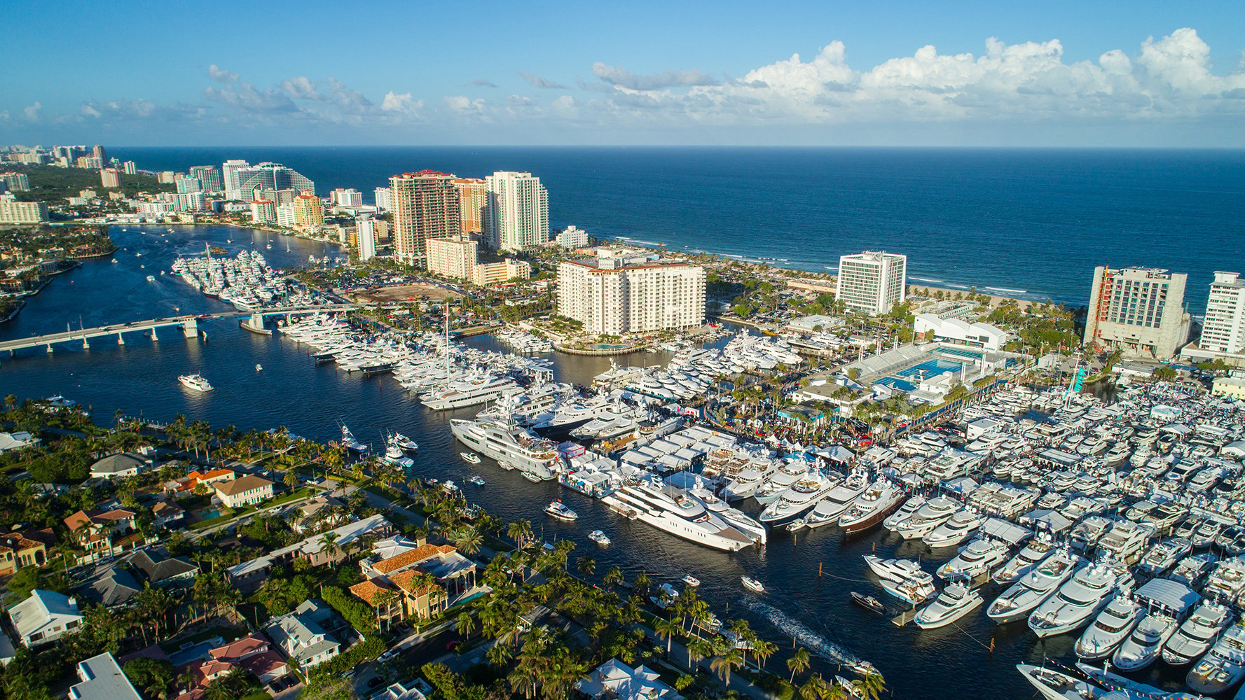 Fort Lauderdale marina aerial with yachts and skyline, prime zone for luxury and ultra luxury condos, offering preconstruction and resale. Featuring view.