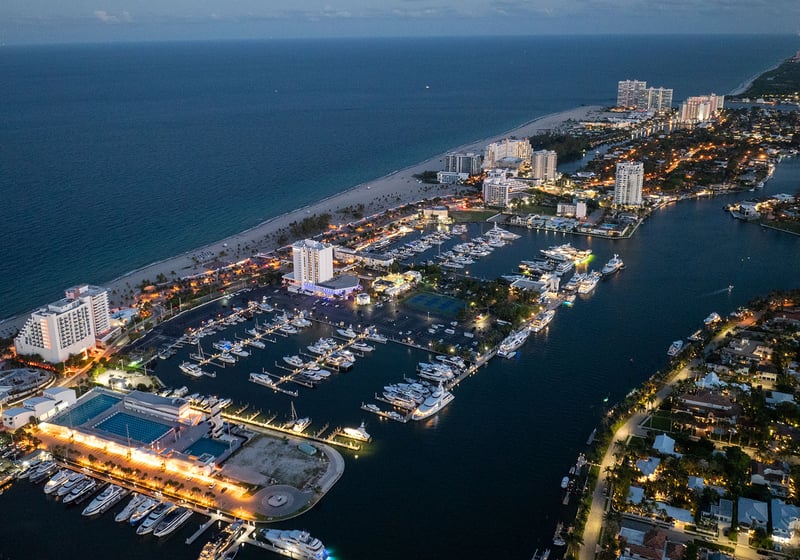 Aerial night view of Fort Lauderdale overlooking Bahia Mar marina, yachts and beachfront, showcasing luxury and ultra luxury preconstruction condos on the Intracoastal Waterway.