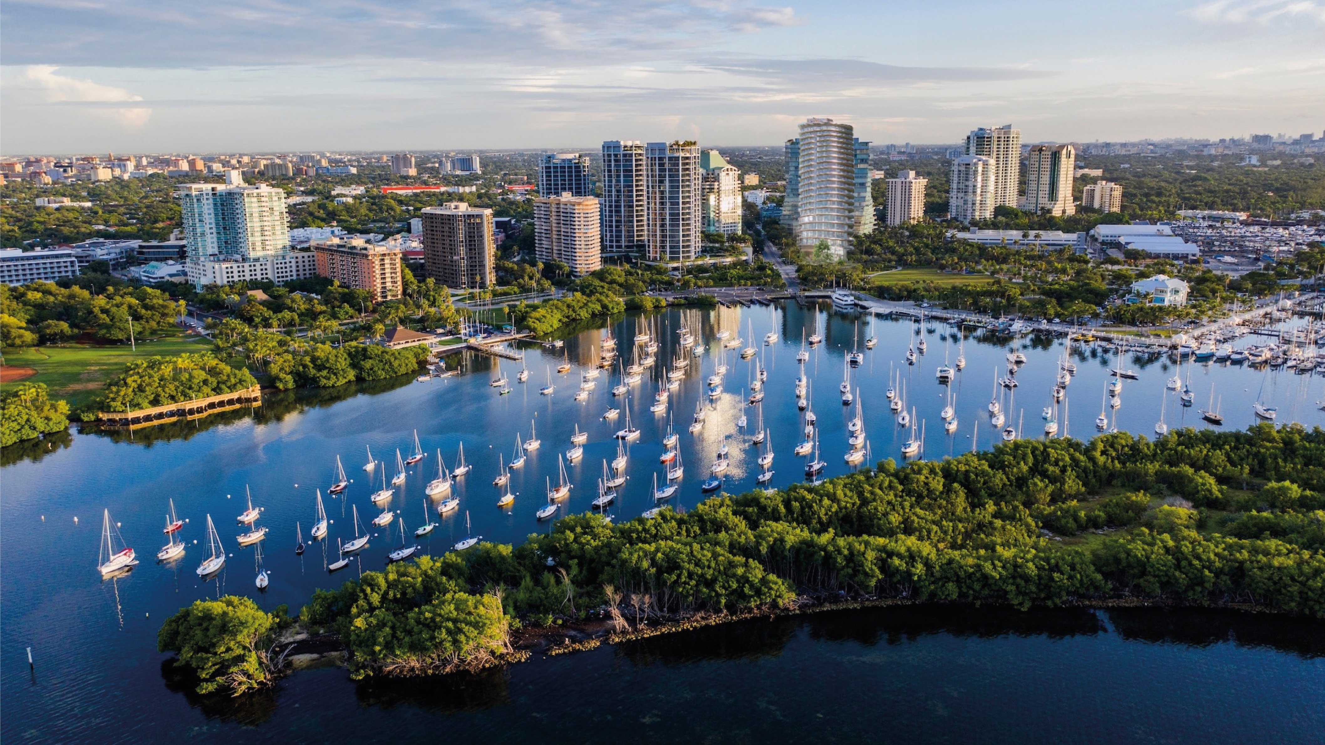 Four Seasons Coconut Grove, Miami waterfront marina at sunset with urban skyline, bayfront tower offering luxury and ultra luxury condos; prime preconstruction in Coconut Grove.