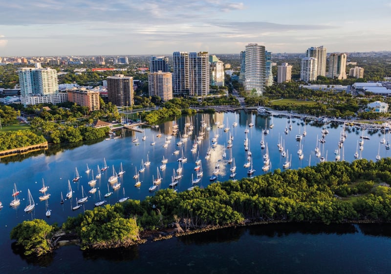Four Seasons Coconut Grove, Miami waterfront marina at sunset with urban skyline, bayfront tower offering luxury and ultra luxury condos; prime preconstruction in Coconut Grove.