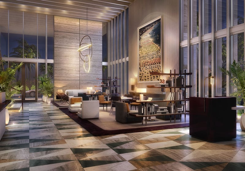 Double-height lobby lounge at twilight with sculptural lighting and lofty glazing at Four Seasons Residences Fort Lauderdale in Fort Lauderdale, introducing luxury and ultra luxury condos with a dramatic arrival experience.