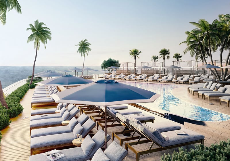 Oceanfront pool terrace with palm trees, umbrella-shaded loungers, and cabanas at Four Seasons Residences Fort Lauderdale in Fort Lauderdale, showcasing luxury and ultra luxury condos with resort-style leisure spaces.