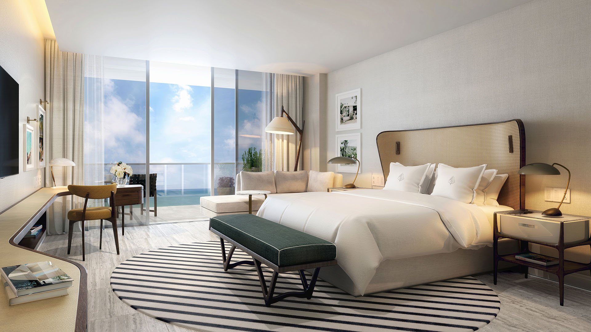 Primary bedroom with an ocean-view balcony, desk, and lounge seating at Four Seasons Residences Fort Lauderdale in Fort Lauderdale, highlighting luxury and ultra luxury condos with calm coastal bedroom design.