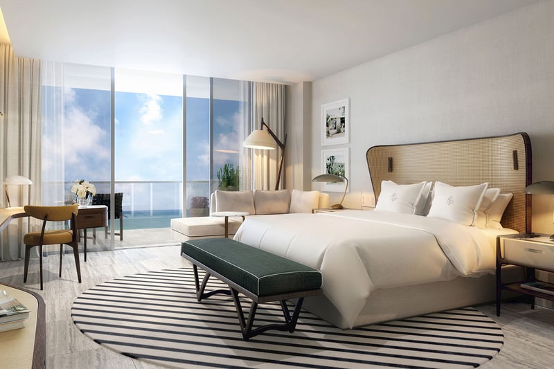 Primary bedroom with an ocean-view balcony, desk, and lounge seating at Four Seasons Residences Fort Lauderdale in Fort Lauderdale, highlighting luxury and ultra luxury condos with calm coastal bedroom design.