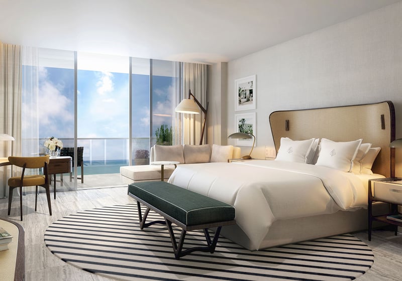 Primary bedroom with an ocean-view balcony, desk, and lounge seating at Four Seasons Residences Fort Lauderdale in Fort Lauderdale, highlighting luxury and ultra luxury condos with calm coastal bedroom design.
