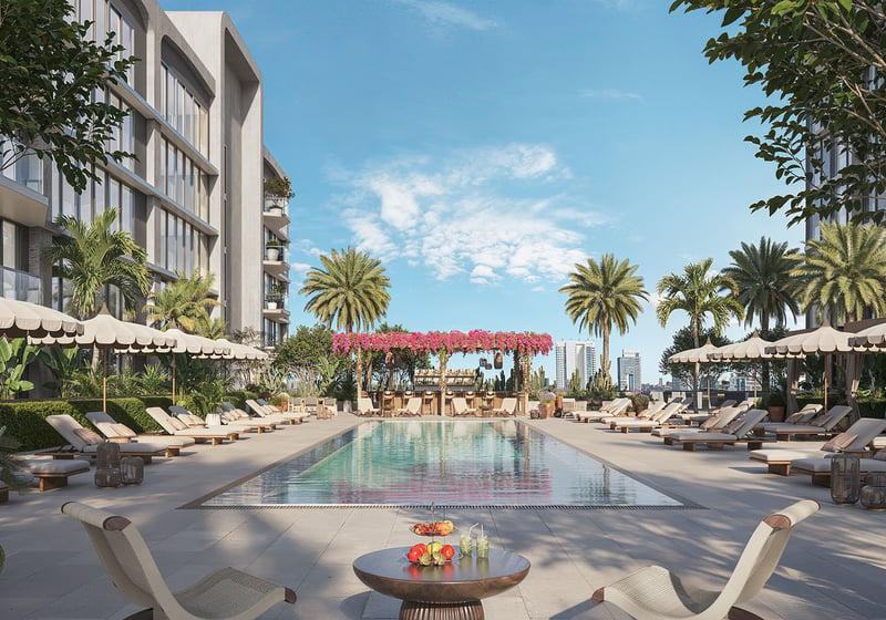 Resort-style pool terrace at Frida Kahlo Residences in Wynwood, created for luxury and ultra luxury condos living with palm trees, sun loungers, umbrellas, and a flower-covered pergola lounge.