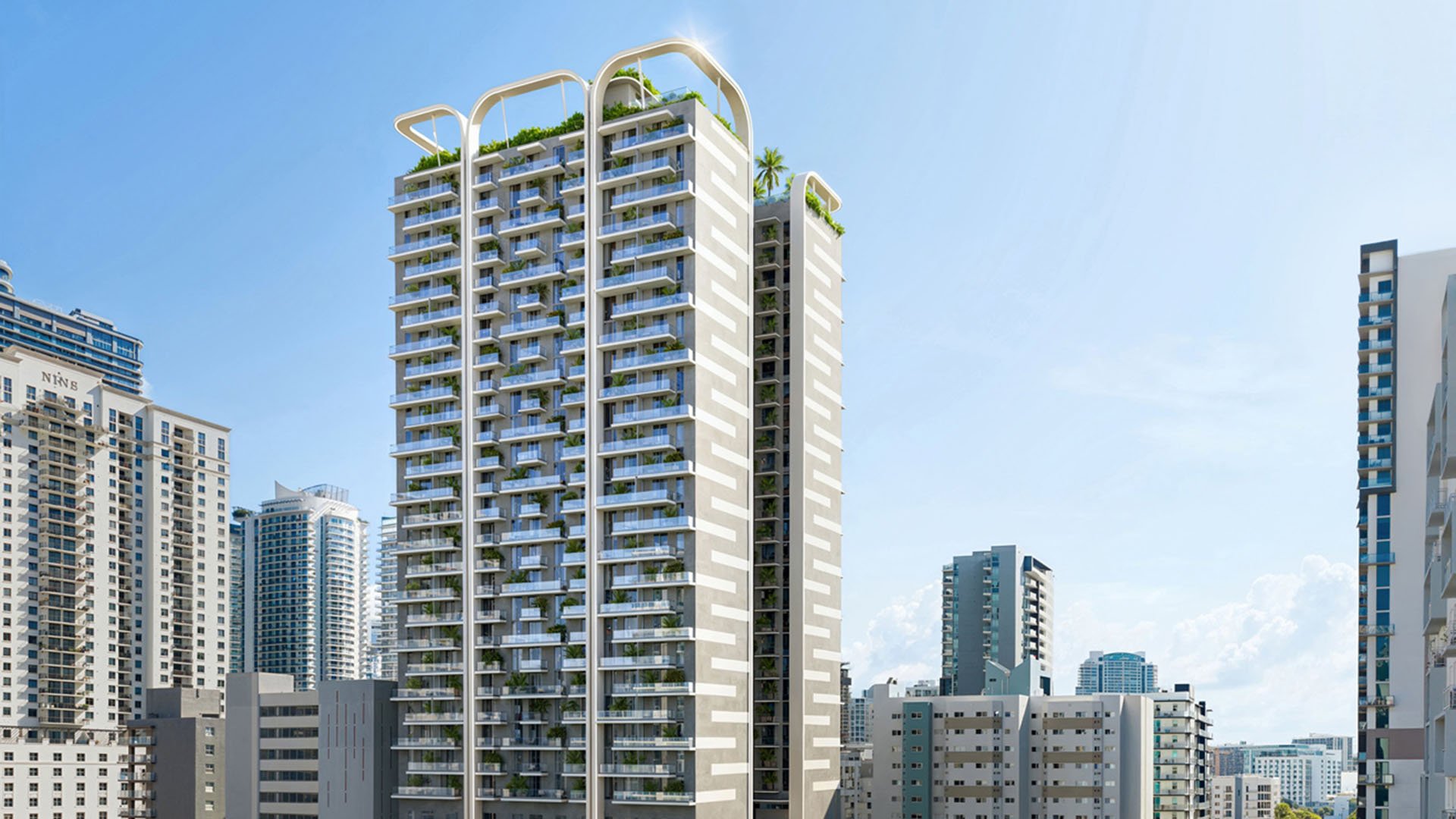 Daytime exterior of House of Wellness in Brickell preconstruction luxury and ultra luxury condos showing the full tower framed to the left against surrounding skyline buildings.