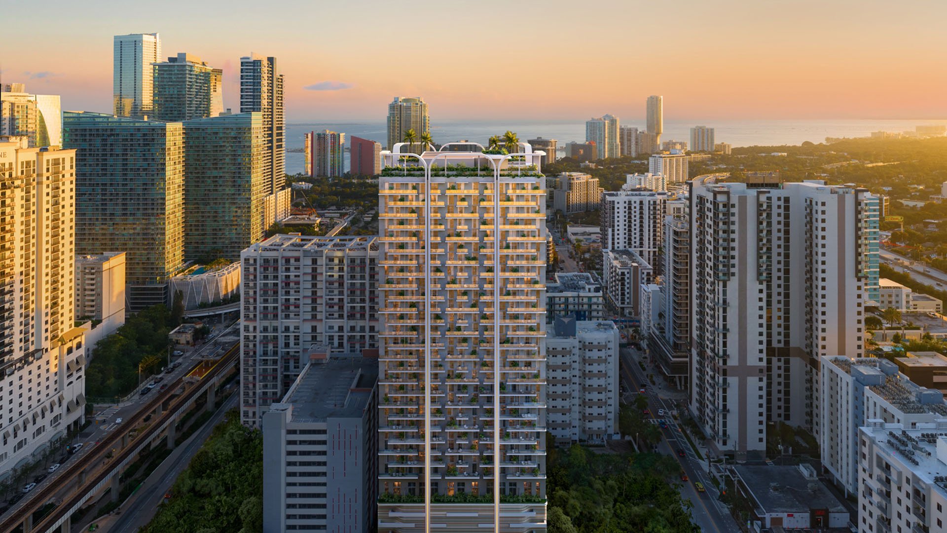 Golden-hour aerial of House of Wellness in Brickell preconstruction luxury and ultra luxury condos centered in the skyline with the bay horizon beyond.