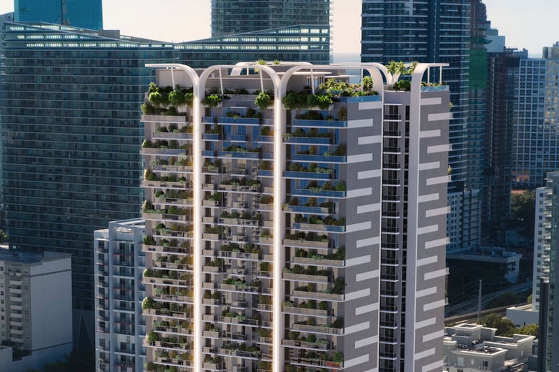 Oblique exterior view of House of Wellness in Brickell preconstruction luxury and ultra luxury condos showing planted balconies, the rooftop crown, and nearby waterfront towers.