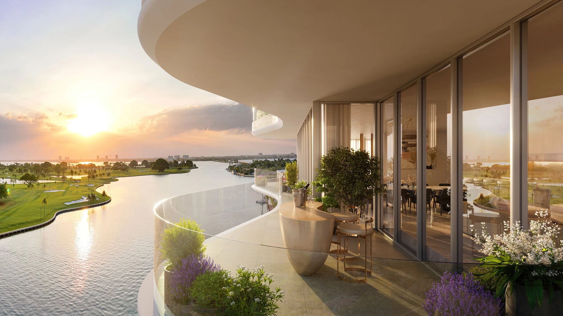 Indian Creek Residences and Yacht Club curved glass balcony at sunset overlooking the waterway and golf course, Bay Harbor Islands, Miami area, Florida, luxury and ultra luxury preconstruction condos with outdoor seating.
