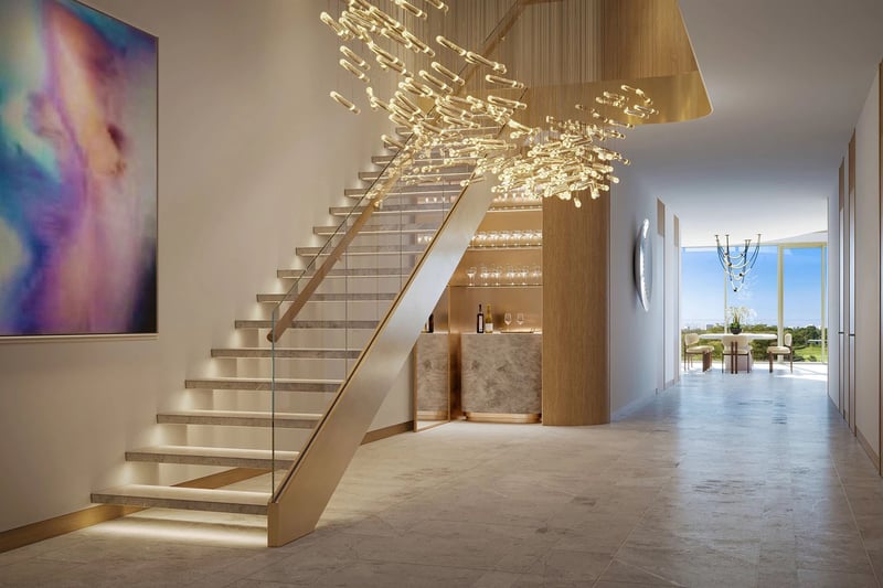 Indian Creek Residences and Yacht Club duplex entry foyer with floating staircase and sculptural chandelier, modern bar and gallery art, Bay Harbor Islands, Miami area, Florida, luxury and ultra luxury preconstruction condos interiors.