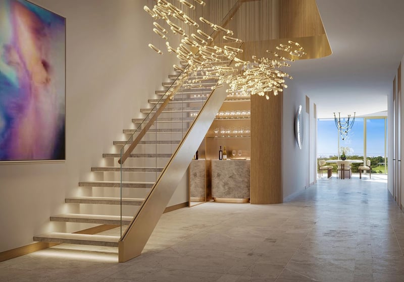Indian Creek Residences and Yacht Club duplex entry foyer with floating staircase and sculptural chandelier, modern bar and gallery art, Bay Harbor Islands, Miami area, Florida, luxury and ultra luxury preconstruction condos interiors.