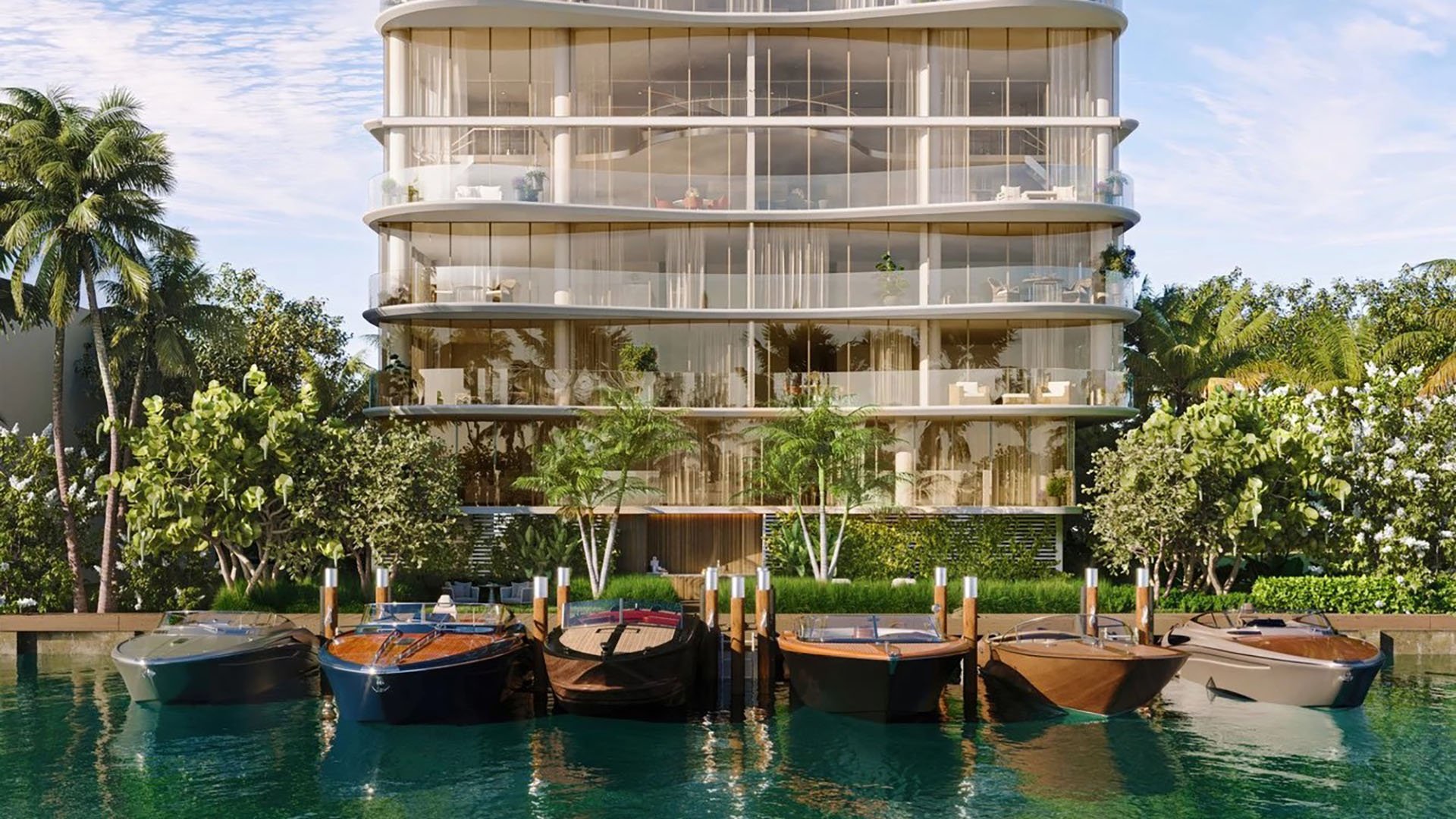 Indian Creek Residences and Yacht Club waterfront residences and yacht club with boats docked at private slips, curved glass facade, Bay Harbor Islands, Miami area, Florida, luxury and ultra luxury preconstruction condos.