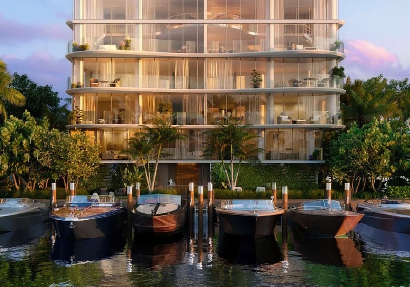 Indian Creek Residences and Yacht Club in Bay Harbor Islands, Miami, Florida modern glass waterfront condo building and yacht club marina with luxury boats, representing ultra luxury preconstruction condos with private dockage.