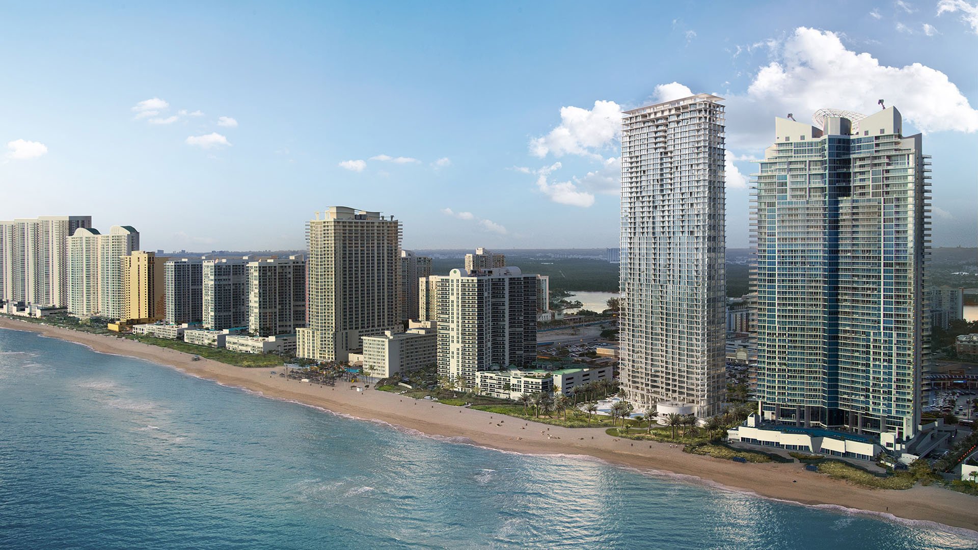 Jade Signature in Sunny Isles Beach luxury and ultra luxury condos aerial beachfront skyline view showing the tower along a sandy shoreline with neighboring high rises and bright blue water.