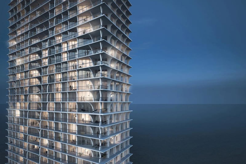 Jade Signature in Sunny Isles Beach luxury and ultra luxury condos closeup of the oceanfront tower facade at blue hour, showing curved balconies, floor to ceiling glass and the dark blue sea beyond.