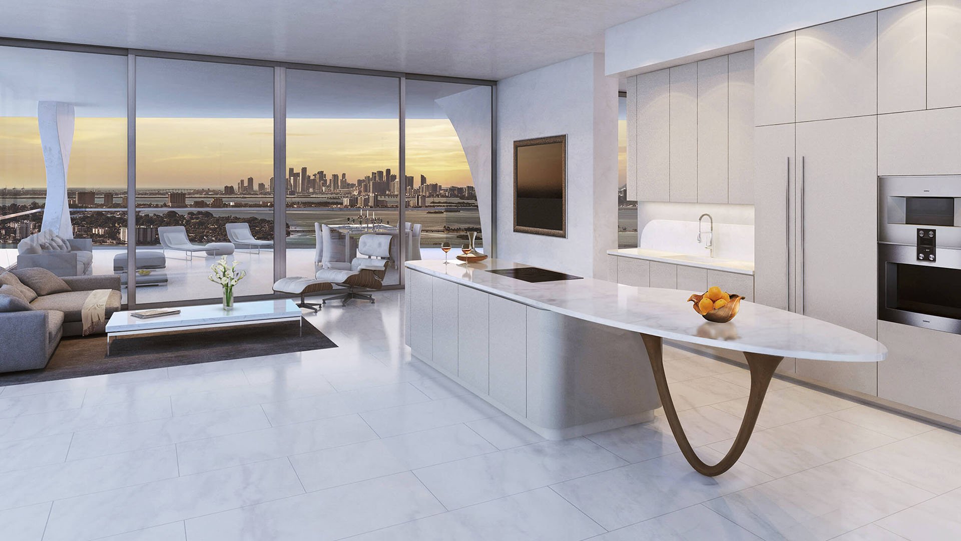 Jade Signature in Sunny Isles Beach luxury and ultra luxury condos chef kitchen and living area with a marble island, sunset skyline view and a large terrace beyond the glass.