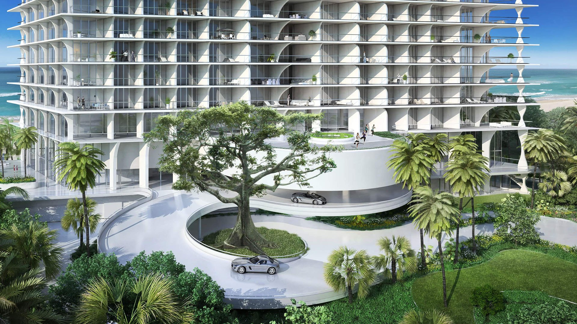Jade Signature in Sunny Isles Beach luxury and ultra luxury condos entrance view with a curved porte cochere, sweeping driveway, tropical landscaping and the sculpted tower facade.