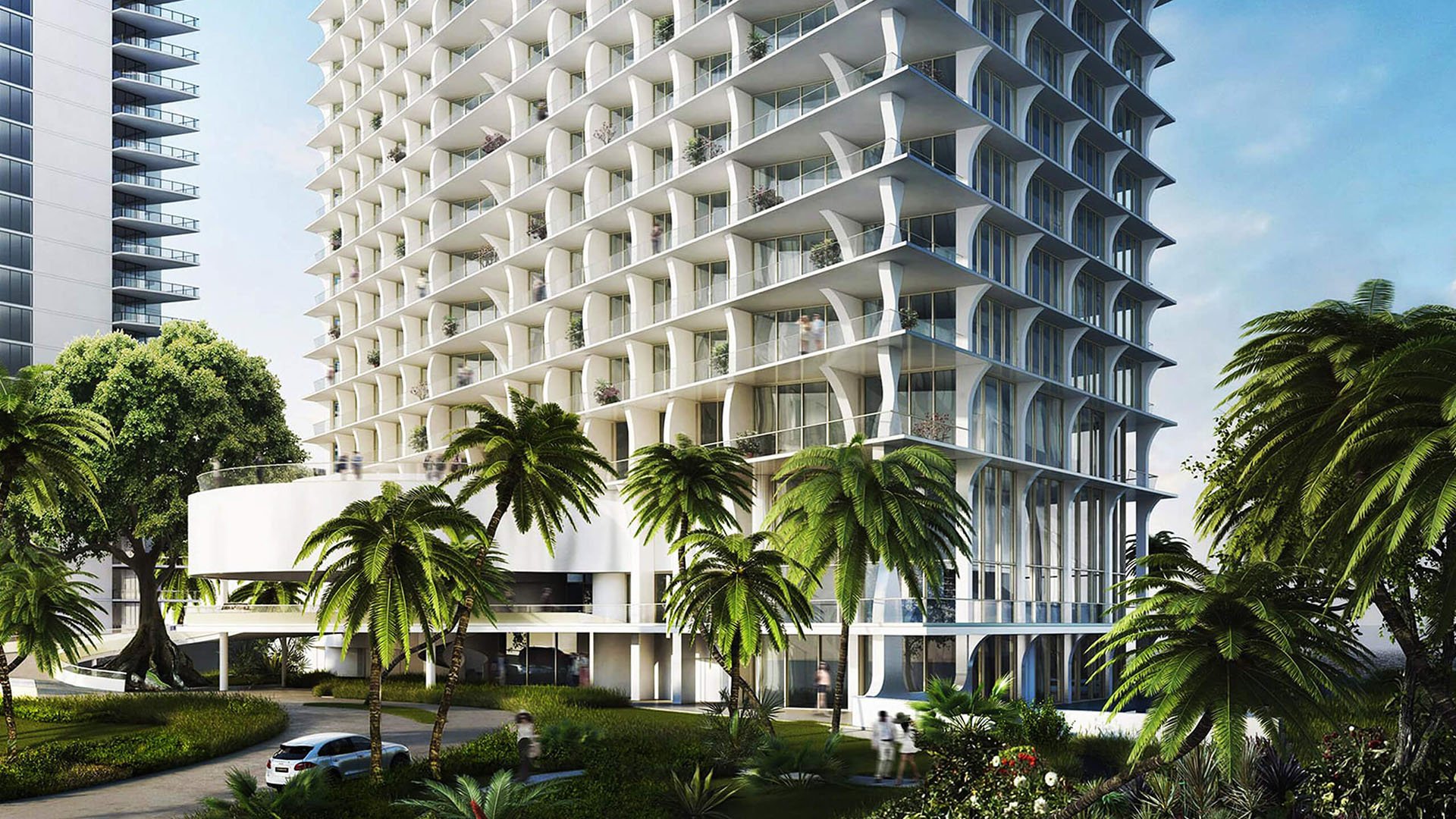 Jade Signature in Sunny Isles Beach luxury and ultra luxury condos palm framed curved exterior showing sculpted balconies, glass walls and lush landscaping at the tower base.