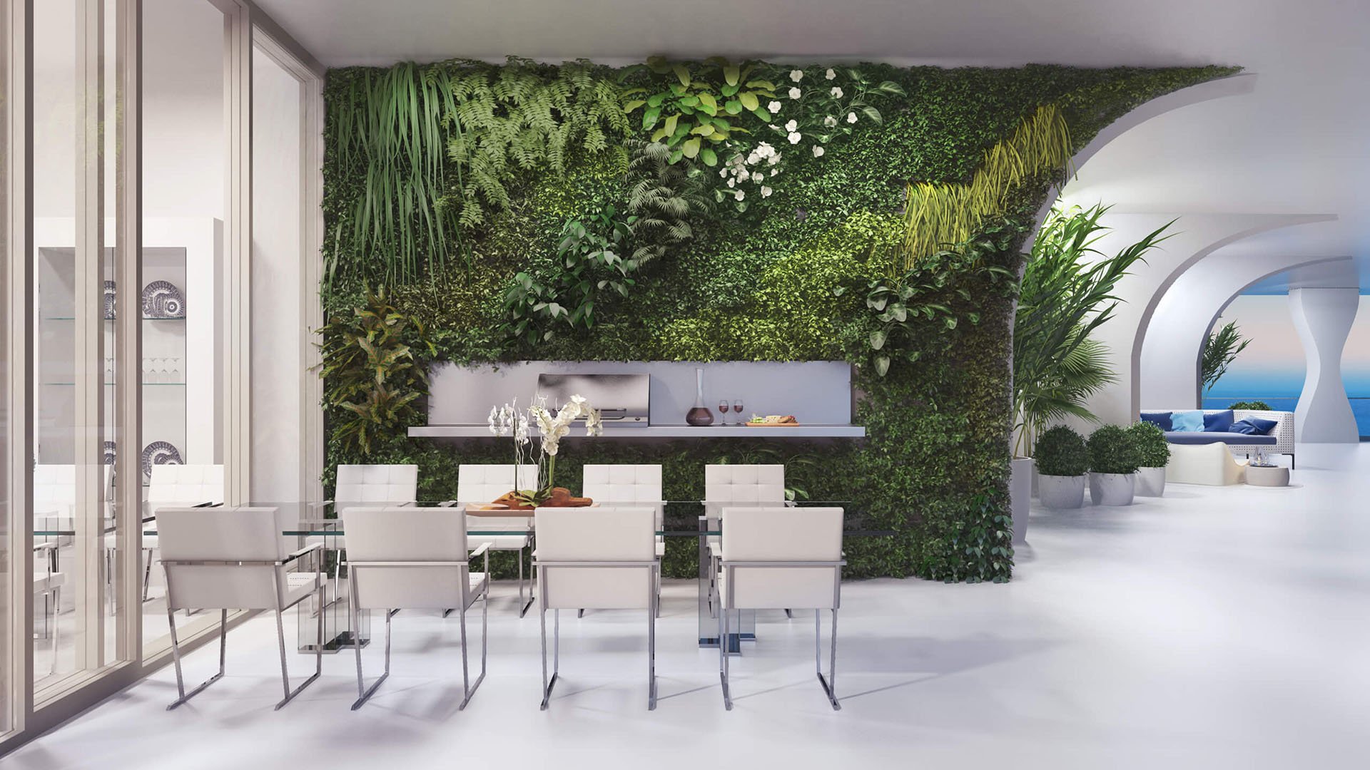 Jade Signature in Sunny Isles Beach luxury and ultra luxury condos private dining room with a lush living wall, modern table setting, indoor outdoor flow and a glimpse of the ocean.