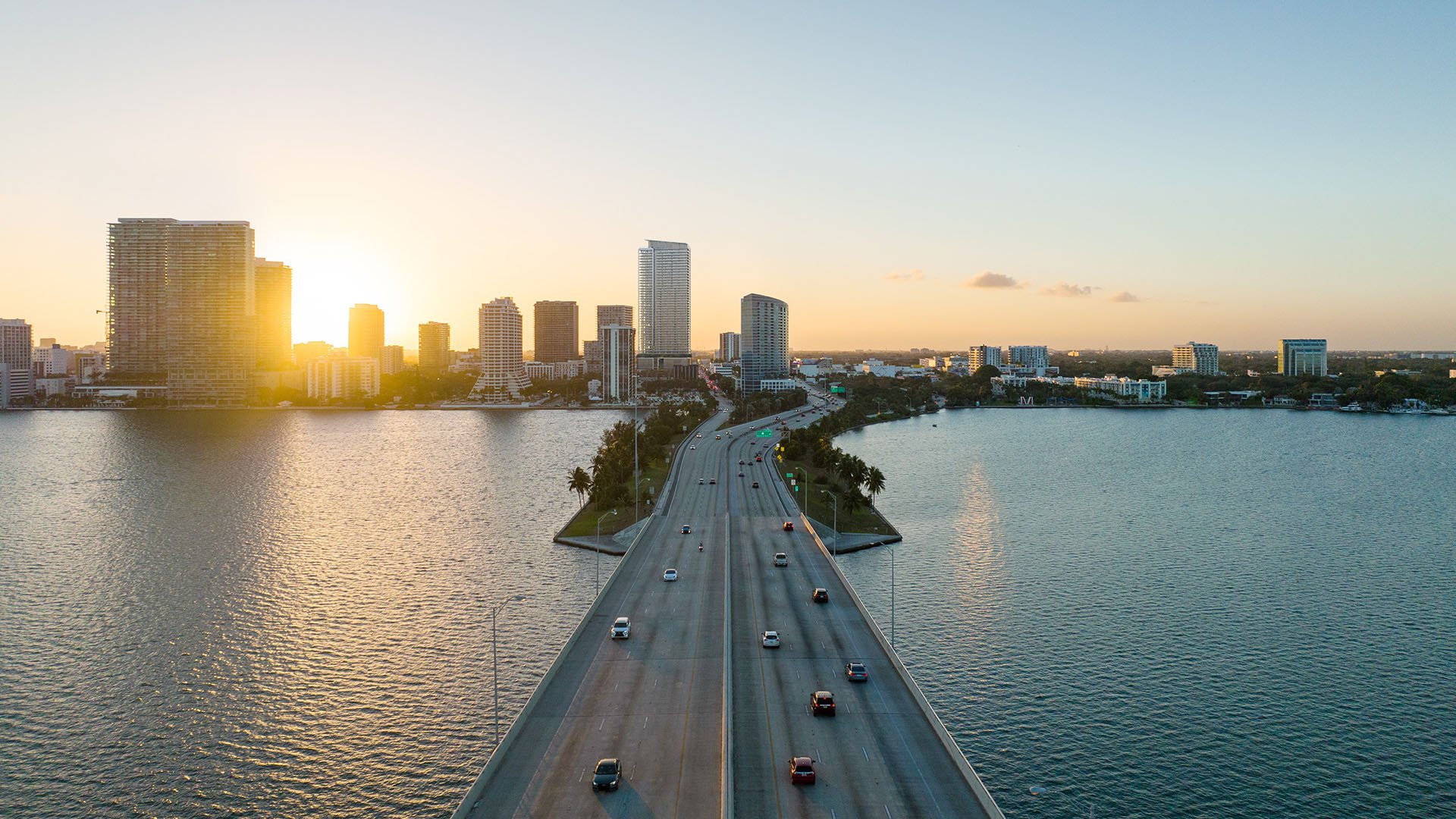 Jean-Georges Miami Tropic Residences sunrise aerial near the Biscayne Bay causeway and Miami skyline, Miami, Florida, representing luxury and ultra luxury preconstruction condos in a prime waterfront location.