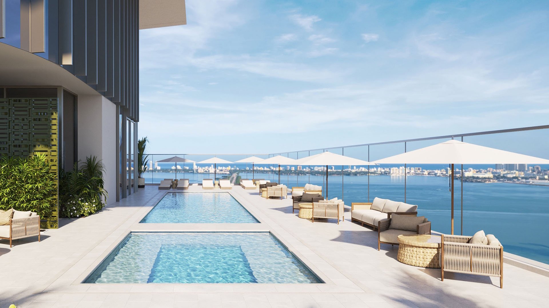Jean-Georges Miami Tropic Residences rooftop pool deck with loungers and white umbrellas overlooking Biscayne Bay, Miami, Florida, highlighting luxury and ultra luxury preconstruction condos with resort-style waterfront amenities.
