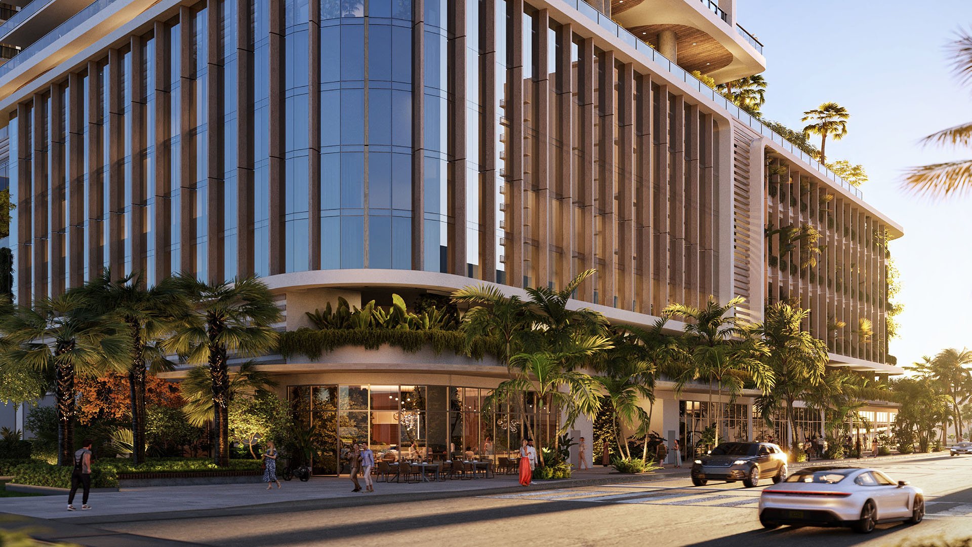 Street-level arrival at Jean-Georges Miami Tropic Residences in Miami, Florida, featuring glass podium, palm-lined streetscape and grand lobby, emphasizing luxury and ultra luxury preconstruction condos in a modern waterfront setting.