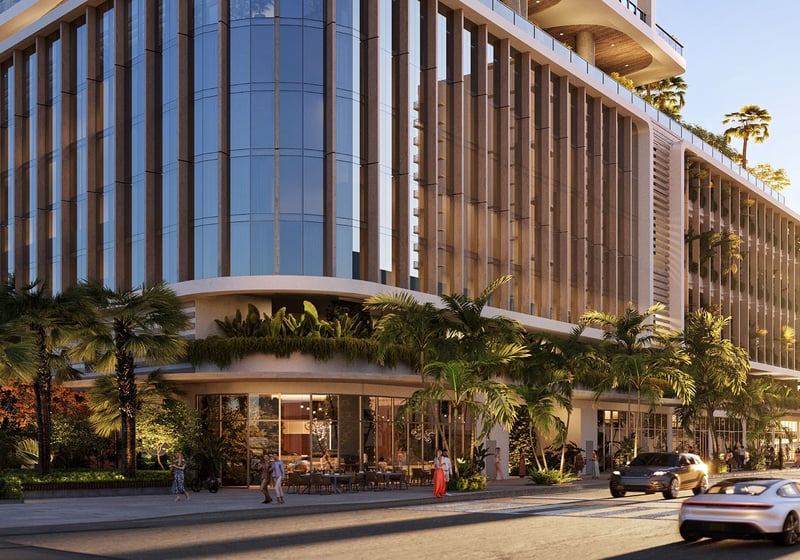 Street-level arrival at Jean-Georges Miami Tropic Residences in Miami, Florida, featuring glass podium, palm-lined streetscape and grand lobby, emphasizing luxury and ultra luxury preconstruction condos in a modern waterfront setting.