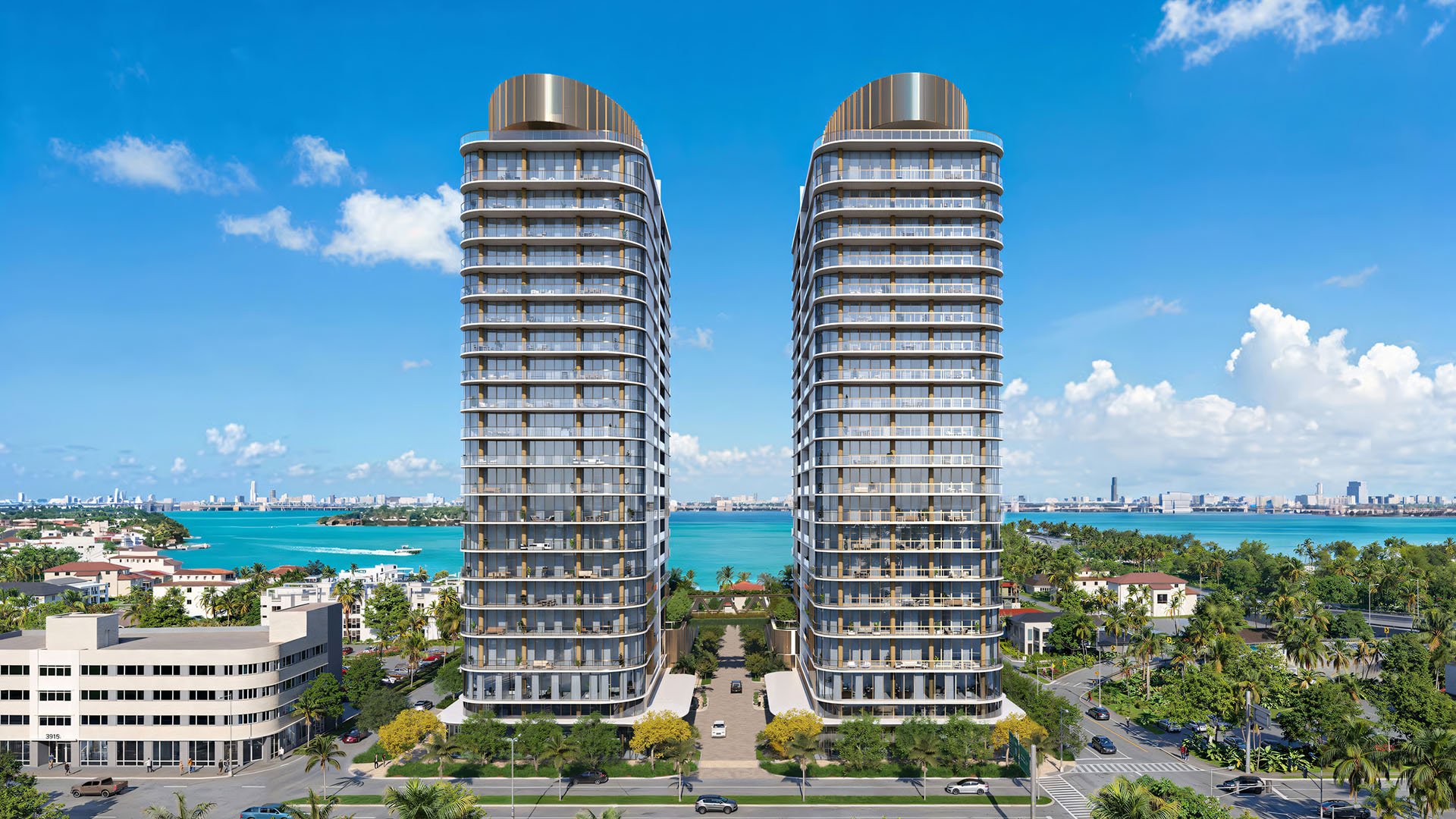 Kempinski Residences Miami in Miami Design District, luxury and ultra luxury condos, preconstruction front elevation of twin curved towers rising above palm-lined streets with sparkling waterfront views behind the residences.
