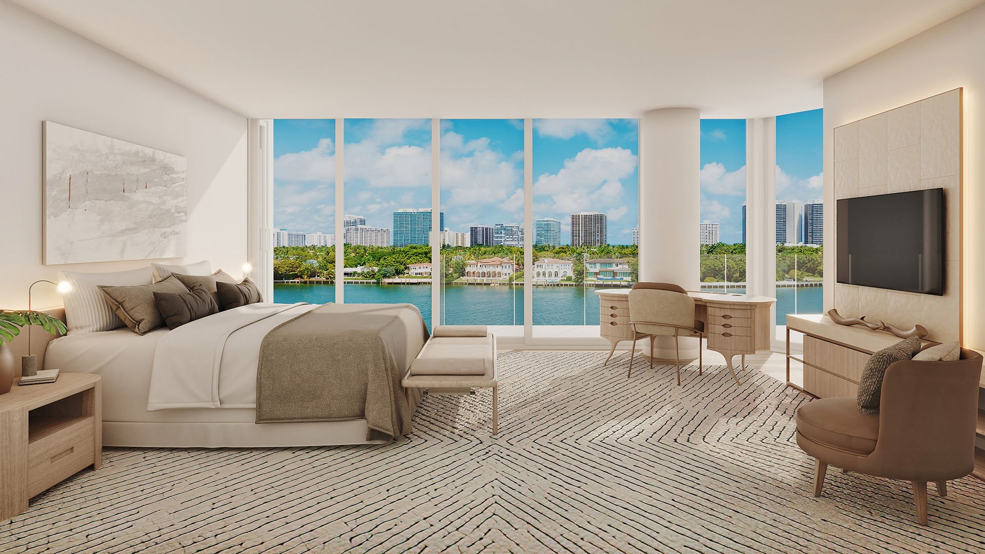 Primary bedroom with floor-to-ceiling glass, waterfront views, sitting area and home office at La Mare Regency Tower unit 5B, Bay Harbor Islands, Miami, Florida, luxury and ultra luxury preconstruction condos interior.