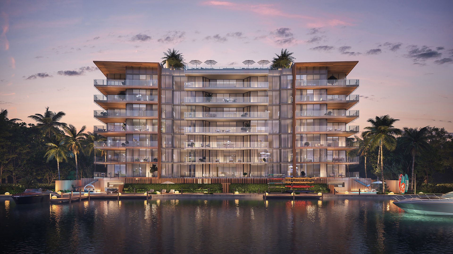 La Mare Regency Tower waterfront exterior at sunset with illuminated balconies, Bay Harbor Islands, Miami, Florida, luxury and ultra luxury preconstruction condos on the bay.