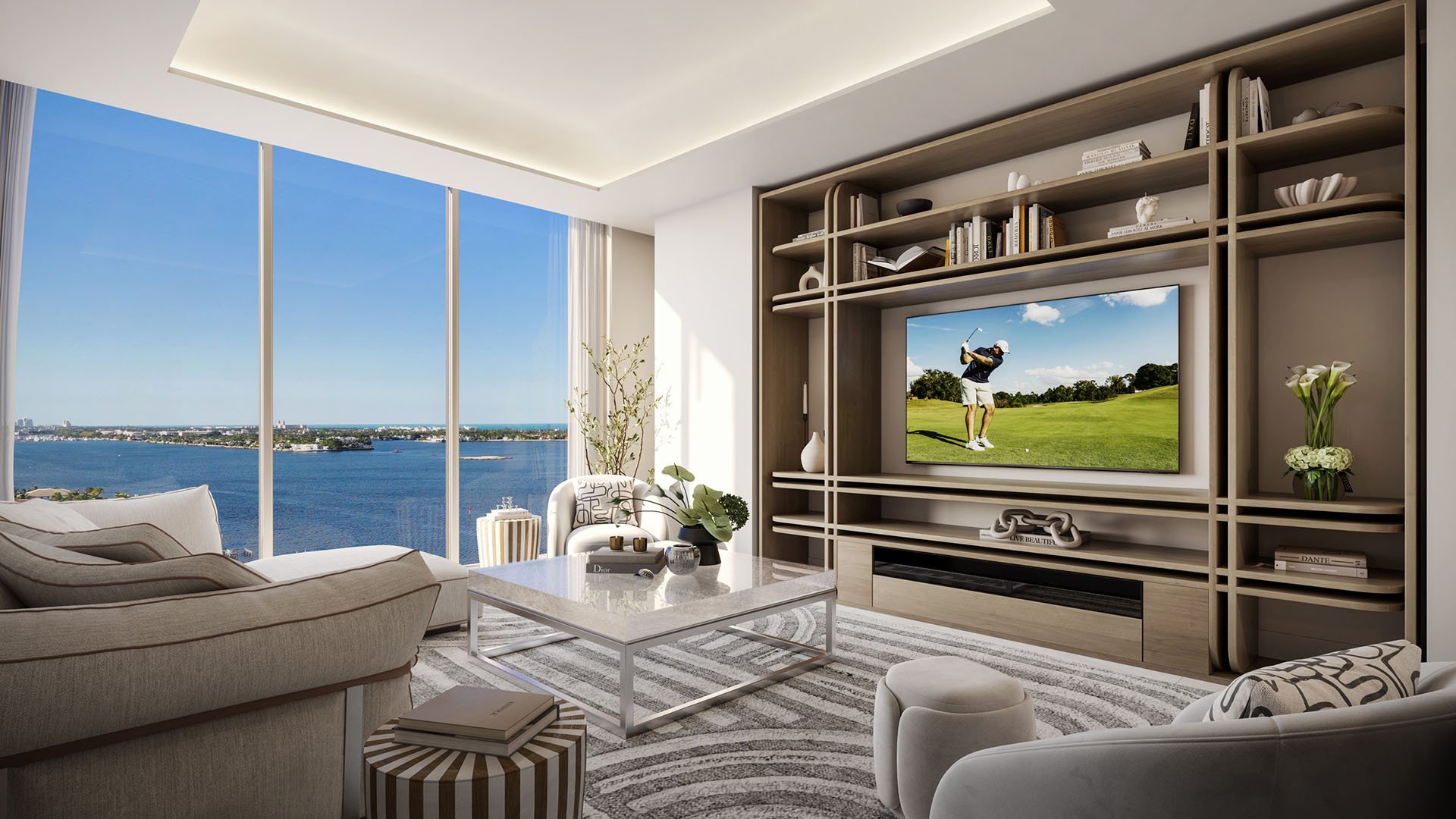 Media room with built-in shelving, television wall and broad water view at Maison D'Or in West Palm Beach, showing luxury and ultra luxury preconstruction condos with comfortable lounge-style interiors.