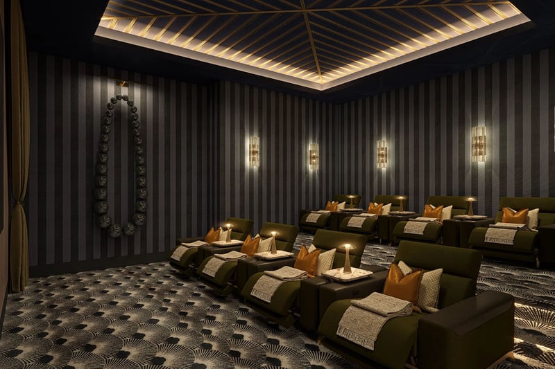 Private screening room with plush recliner seating, dramatic wall sconces and dark patterned carpet at Maison D'Or in West Palm Beach, part of the luxury and ultra luxury preconstruction condos amenities.