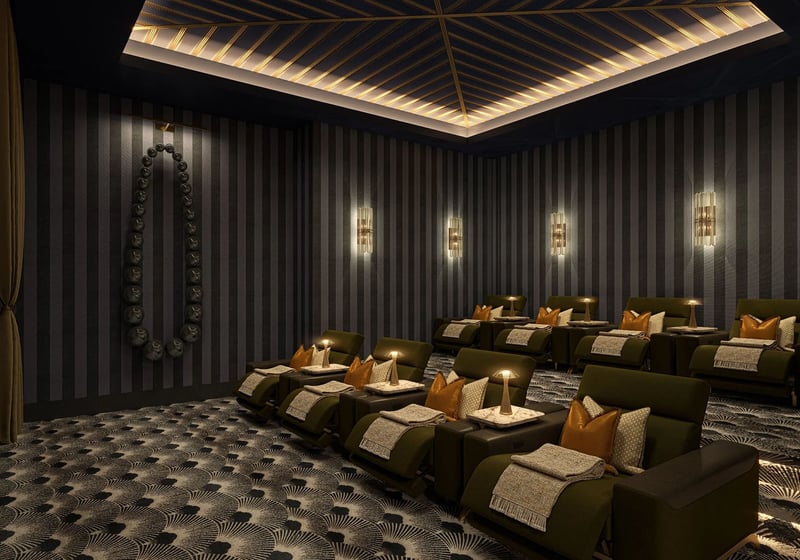 Private screening room with plush recliner seating, dramatic wall sconces and dark patterned carpet at Maison D'Or in West Palm Beach, part of the luxury and ultra luxury preconstruction condos amenities.