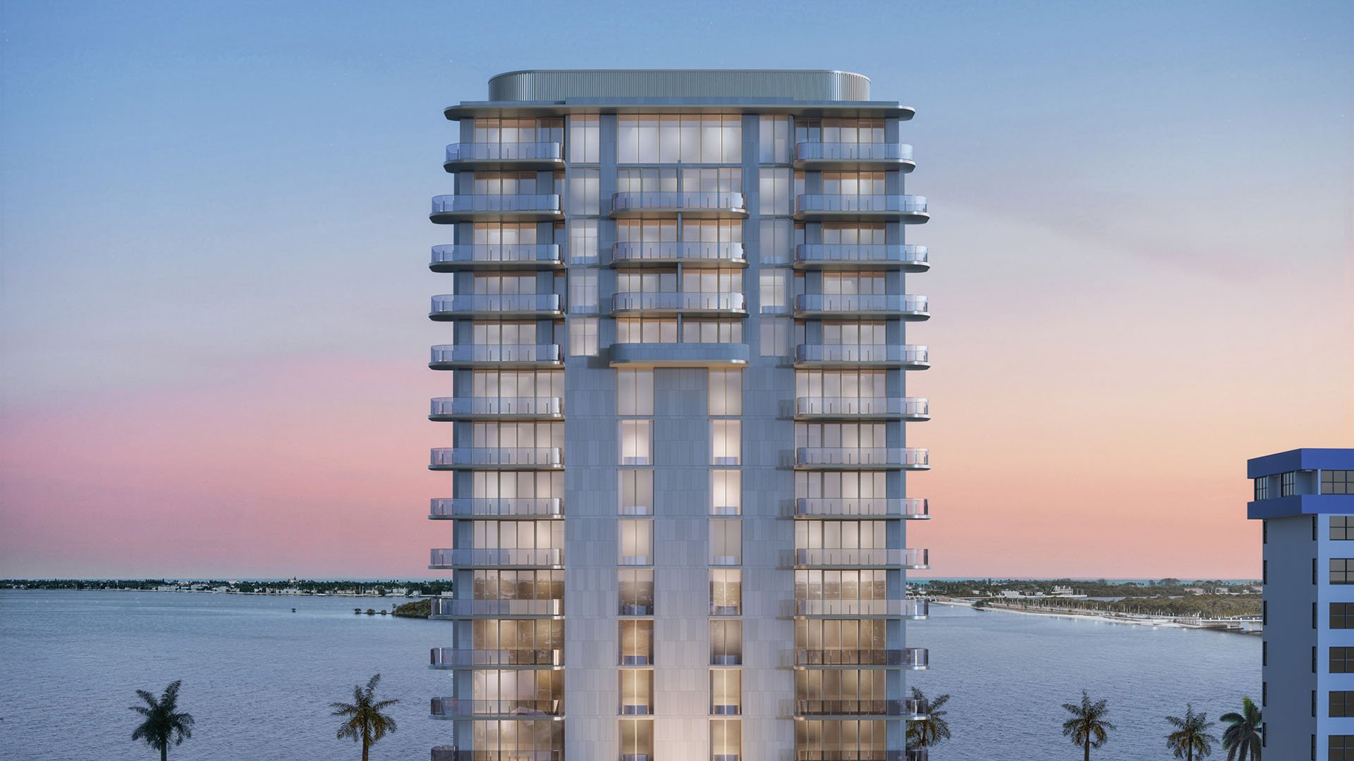 Front elevation of the waterfront tower against a pastel twilight sky at Maison D'Or in West Palm Beach, presenting luxury and ultra luxury preconstruction condos with rounded balconies over the water.